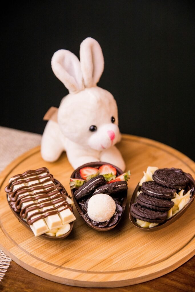 Chocolate Easter egg halves filled with Oreo cookies, cream, strawberries, white chocolate, and Easter dessert toppings.