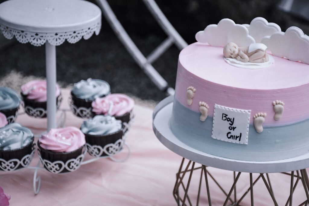 Elegant white gender reveal cake with gold stars and Boy or Girl writing on top.